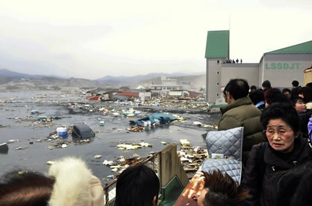 日本，气仙沼：人们在屋顶观看海啸过后的景象